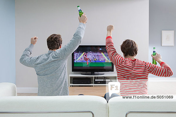 Zwei junge Männer beim Fußball im Fernsehen
