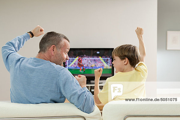 Vater und Sohn schauen Fußball im Fernsehen