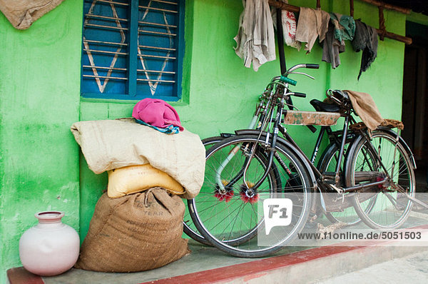 Fahrräder und hessische Säcke und Lappen vor dem Dorfhaus bei Mysore,  Karnataka