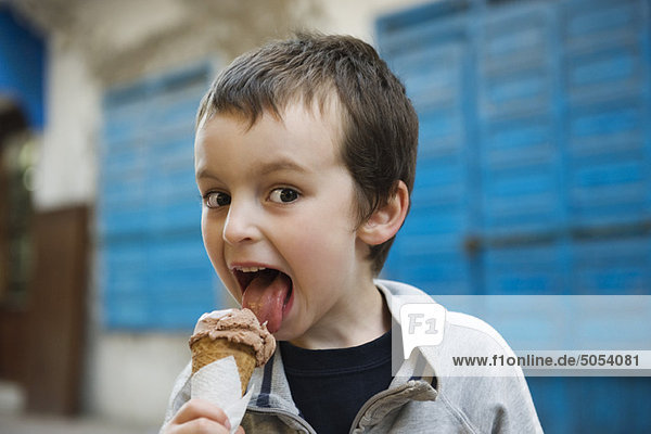Boy licking ice cream cone  portrait