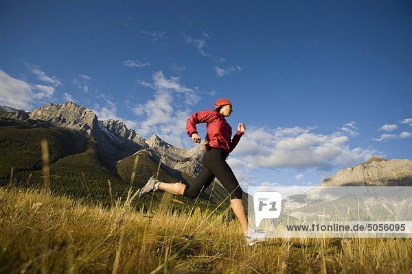 A young woman trail running in Canmore  AB