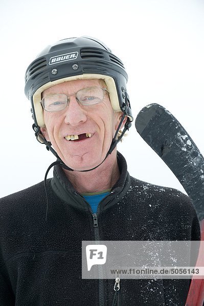 Ein glücklich Eishockeyspieler mit fehlenden Zähne und Stick lächelt  während ein Teich-Hockeyspiel in Rossland  British Columbia  Kanada