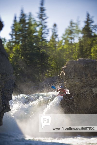 A male kayaker paddles over Elbow Falls  Elbow River  Alberta  Canada