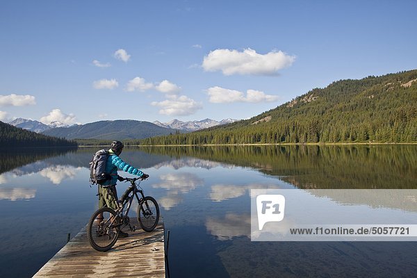 A male mountain biker enjoys a peaceful moment in the morning before an all day ride in Spruce Lake Protected Area  Southern Chilcotins  British Columbia  Canada