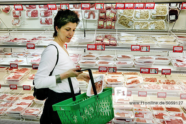 Frau über vierzig Fleisch im Supermarkt kaufen