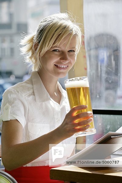 Frau sitzt in der Bar mit einem Glas Bier