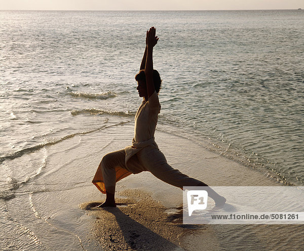 Malediven  Mädchen üben Yoga am Strand