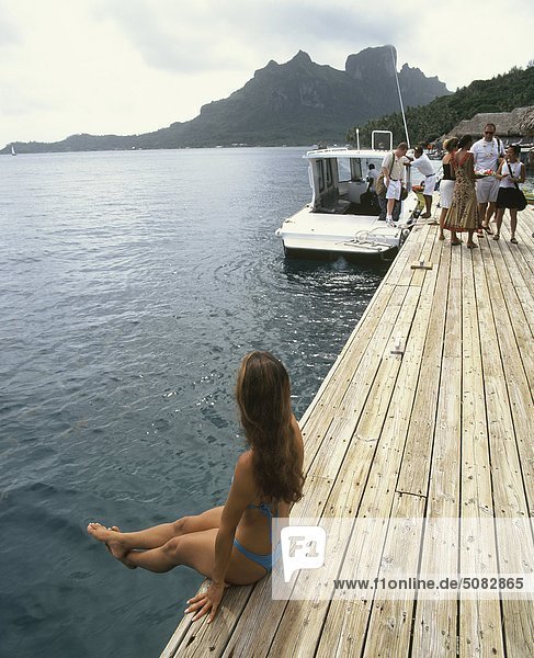 Französisch-Polynesien  Bora Bora. Frau sitzt am pier