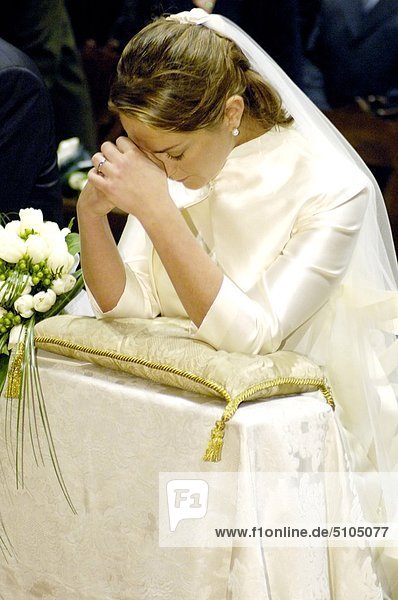 Bride praying during wedding ceremony