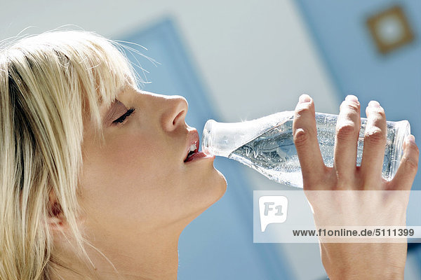 Frau Trinkwasser aus einer Flasche