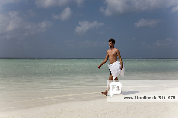 Man carrying pillow on tropical beach