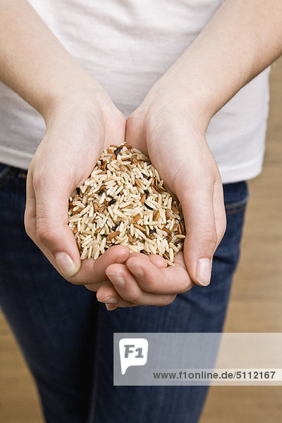 Woman holding handful of wild rice