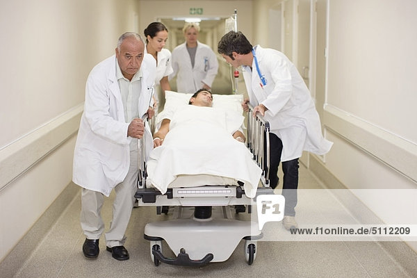 Doctors rushing patient down hallway