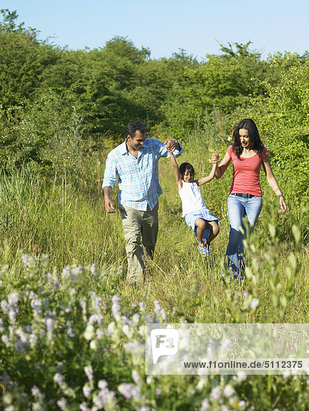 Family walking in field of flowers