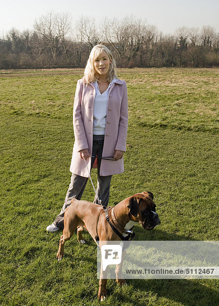 Frau spazieren gehender Hund im Feld
