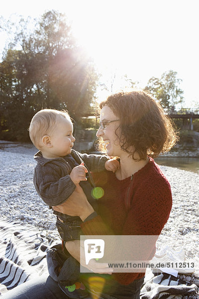 Mother holding baby by creek