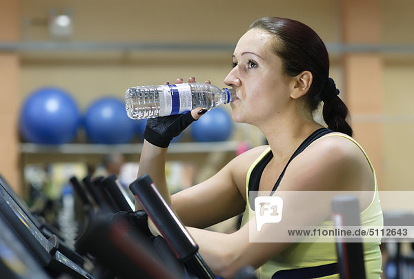 Woman drinking water at gym