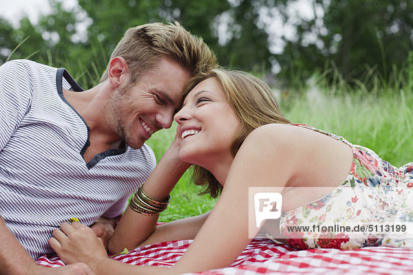 Couple laying on picnic blanket