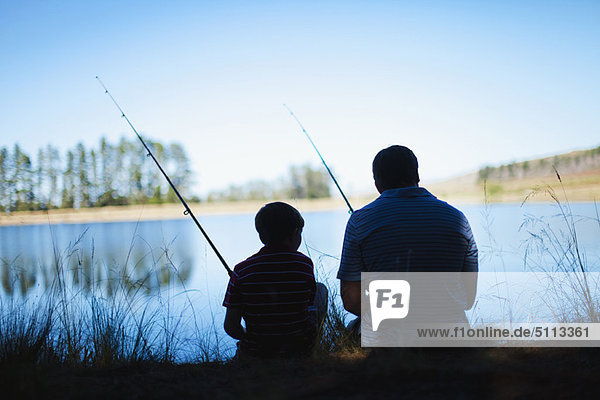 Father fishing with son in lake