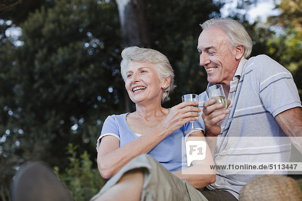 Older couple drinking wine outdoors