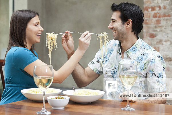 Couple feeding each other spaghetti