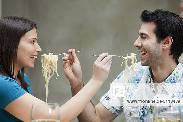 Couple feeding each other spaghetti