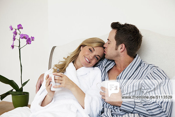 Couple in bathrobes drinking coffee