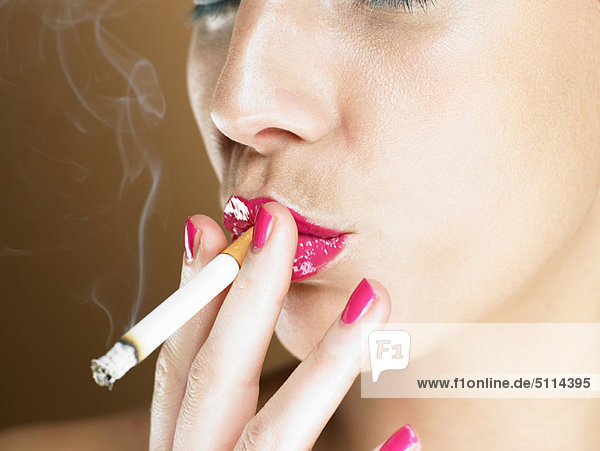 Woman in pink lipstick smoking
