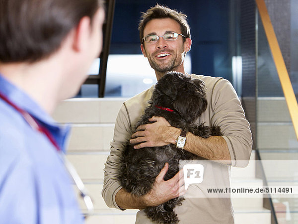 Mann  halten  Hund  Tierarzt