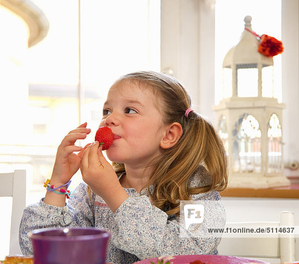 Erdbeere essen essend isst Mädchen Tisch