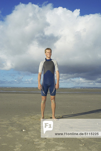 Surfer standing on beach