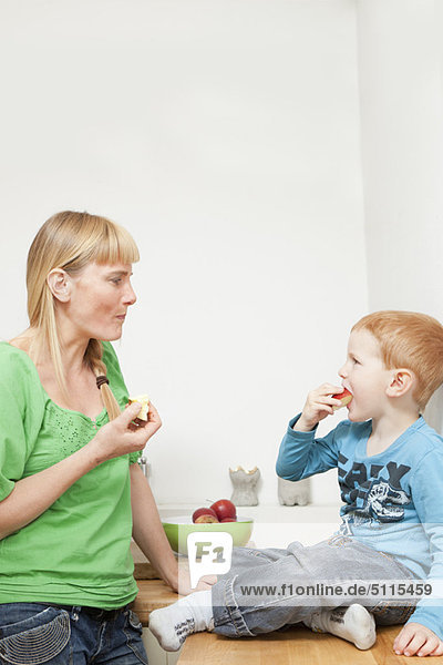 Mutter und Sohn essen gemeinsam Äpfel.