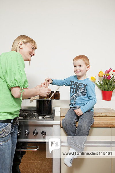 Frau kocht mit Sohn in der Küche