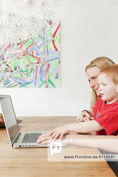 Mutter und Sohn benutzen gemeinsam einen Laptop