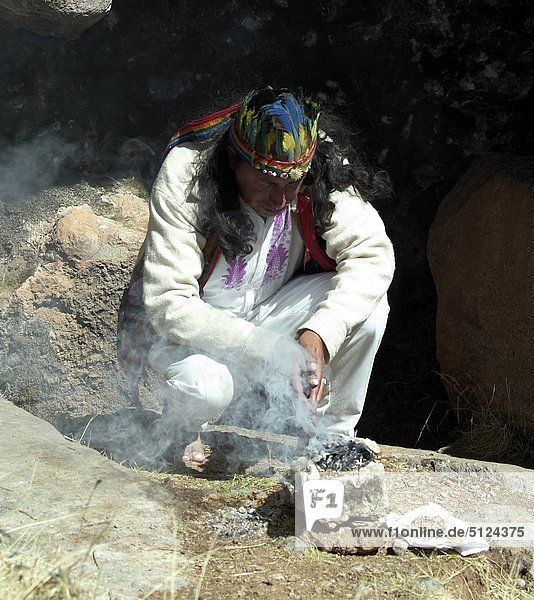 Peru  Cuzco  Sacsayhuaman Inca ruin  priest celebrating a shamanism during the mass in a cave