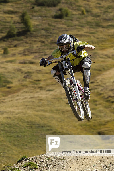Italy  Livigno  View of man jumping with mountain bike