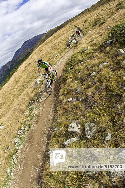 Italy  Livigno  View of woman and man riding mountain bike downhill