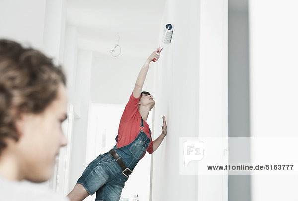 Germany  Cologne  Young couple painting in renovating apartment