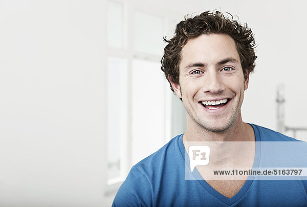 Nahaufnahme eines jungen Mannes in einer renovierten Wohnung  lächelnd  Porträt