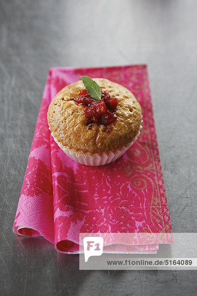 Nahaufnahme von Muffin mit Erdbeerkuchenrelief auf Serviette