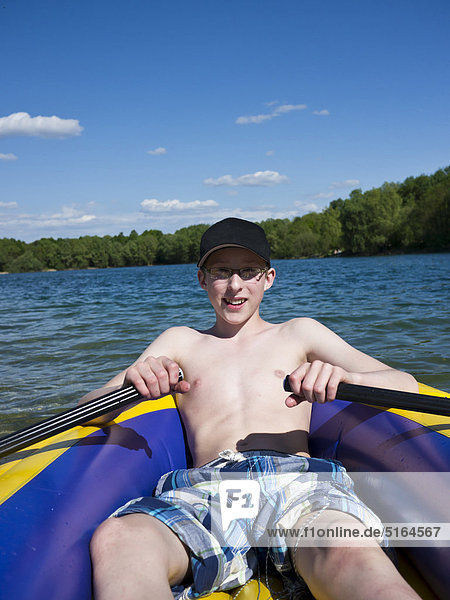 Boy in dinghy rafting at lake  smiling  portrait