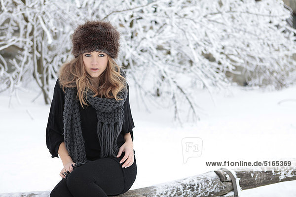Junge Frau mit Schal und Mütze im Schnee