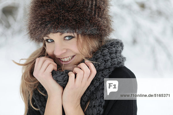 Young woman with scarf and cap in snow