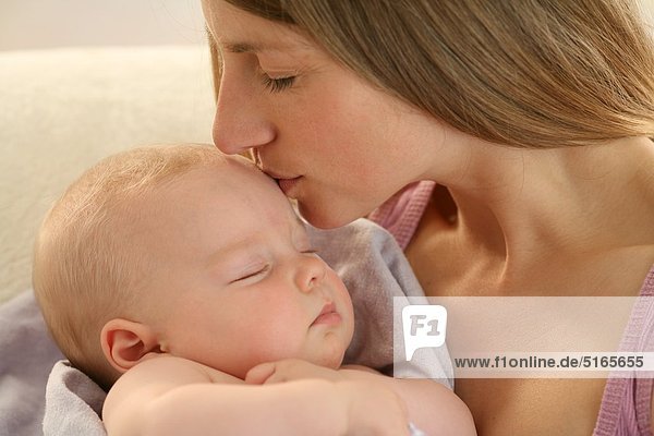 Mutter küsst schlafendes Baby