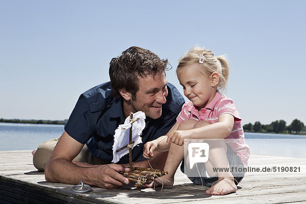Vater und Tochter spielen auf dem Dock