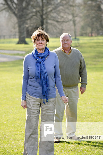 Older couple walking in park
