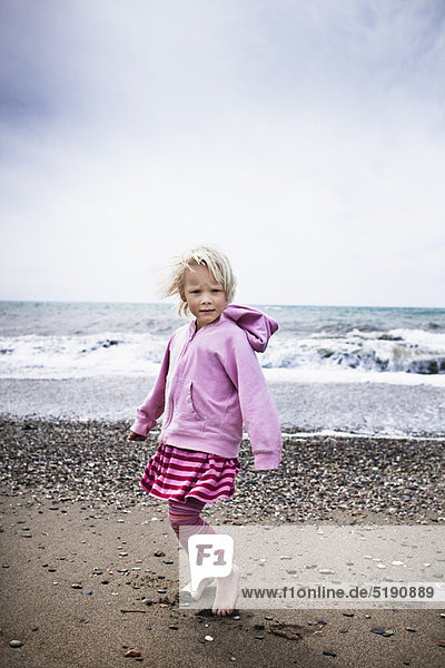 Girl walking barefoot on the beach
