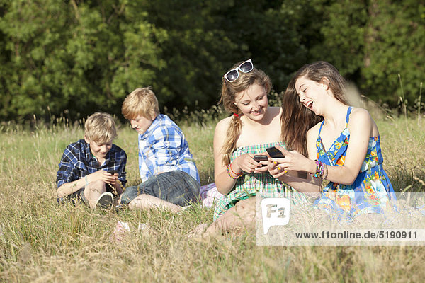 Children using cell phones in field