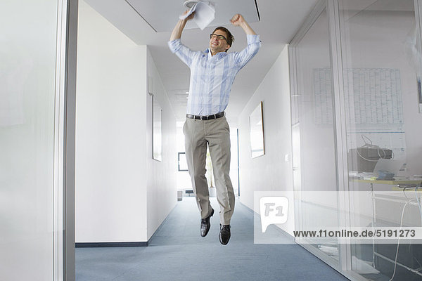 Businessman jumping for joy in office