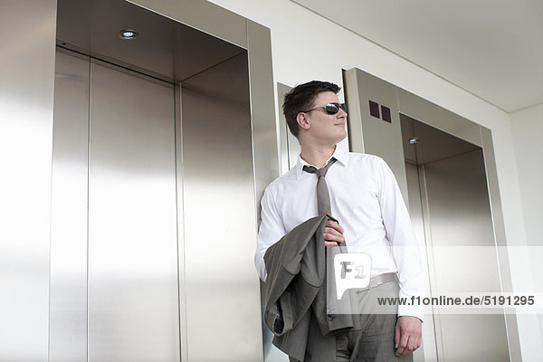 Businessman carrying jacket in lobby